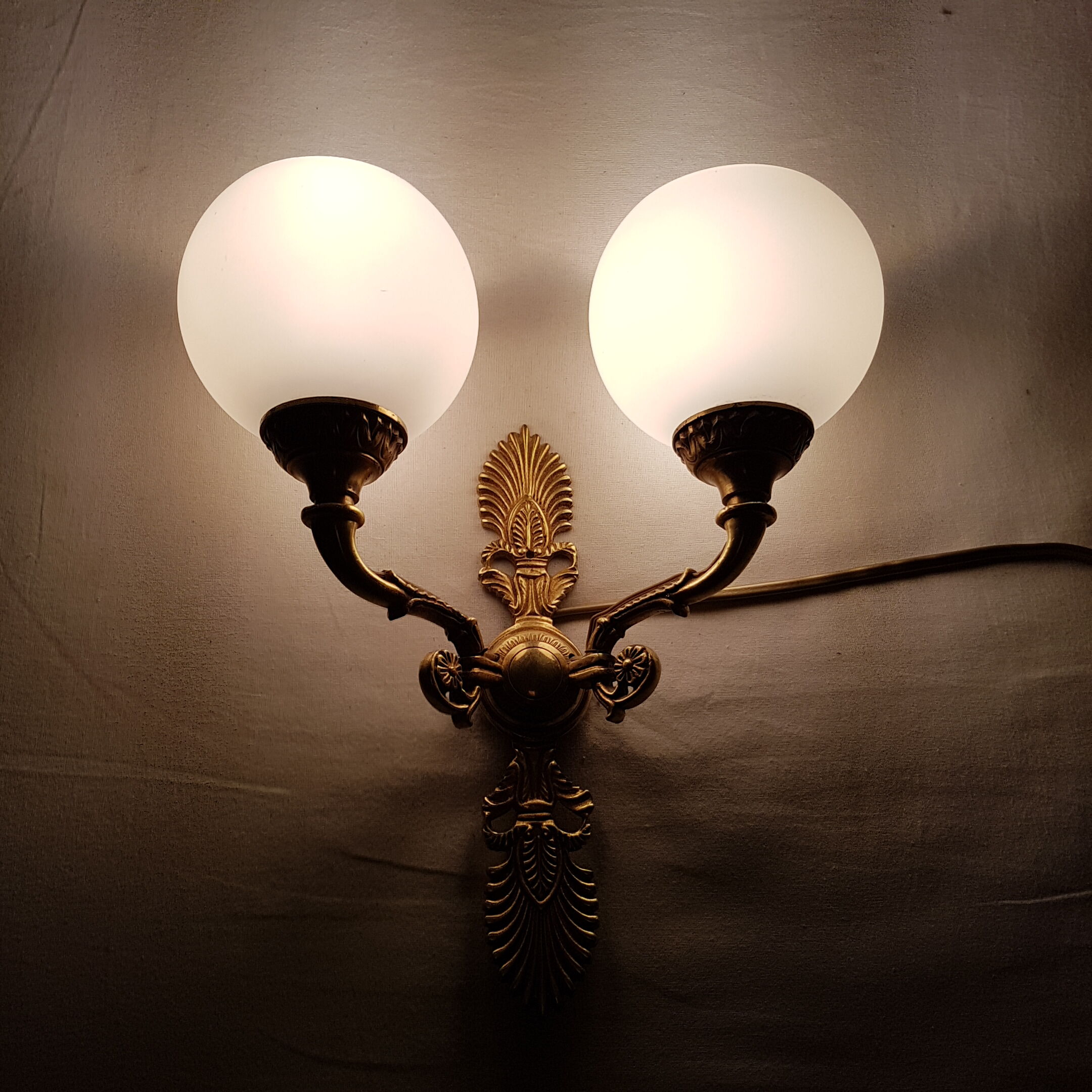 Wall light in gilded bronze and opaque glass globe
