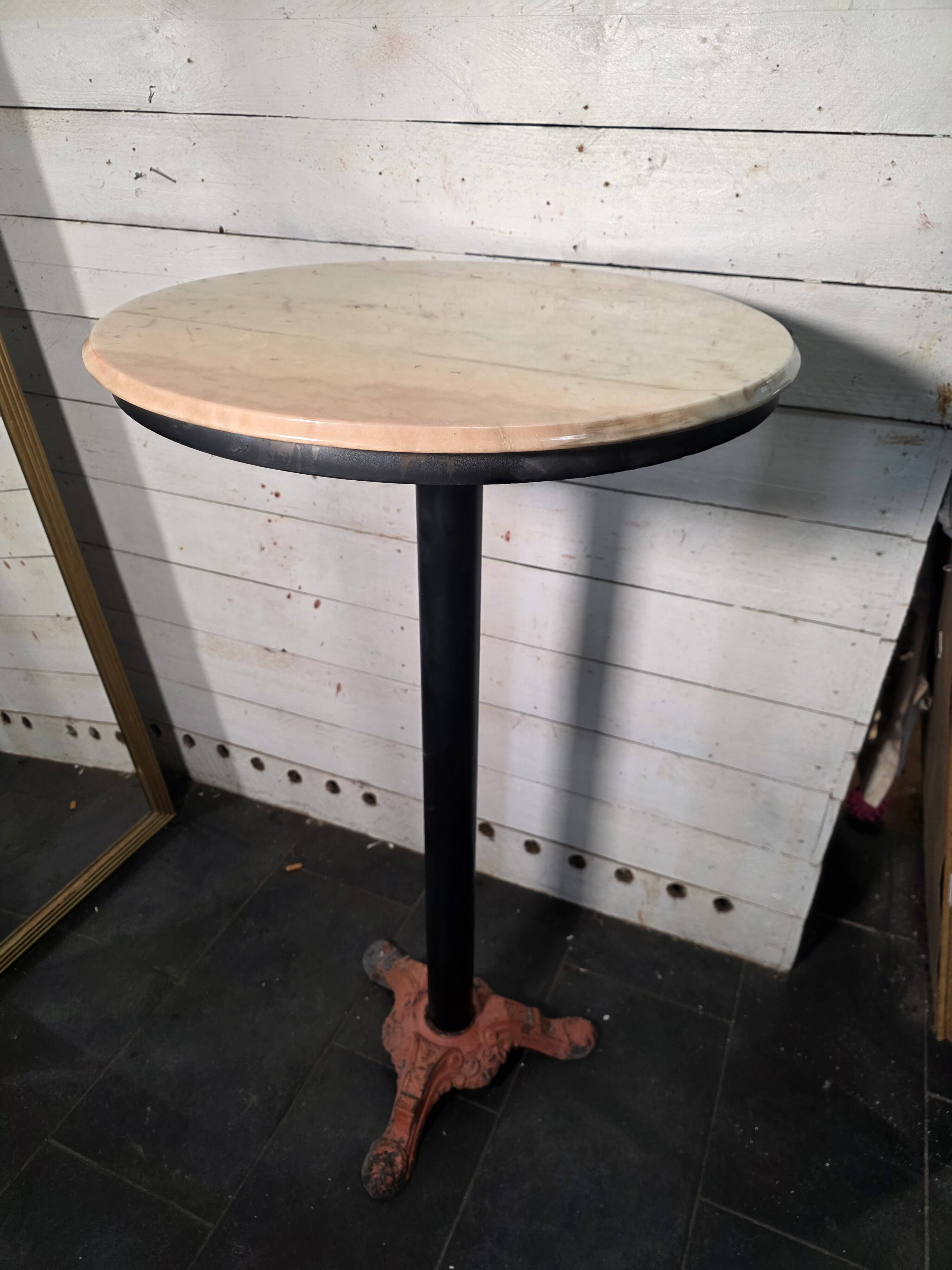 Bistro standing table with marble top and cast iron base.