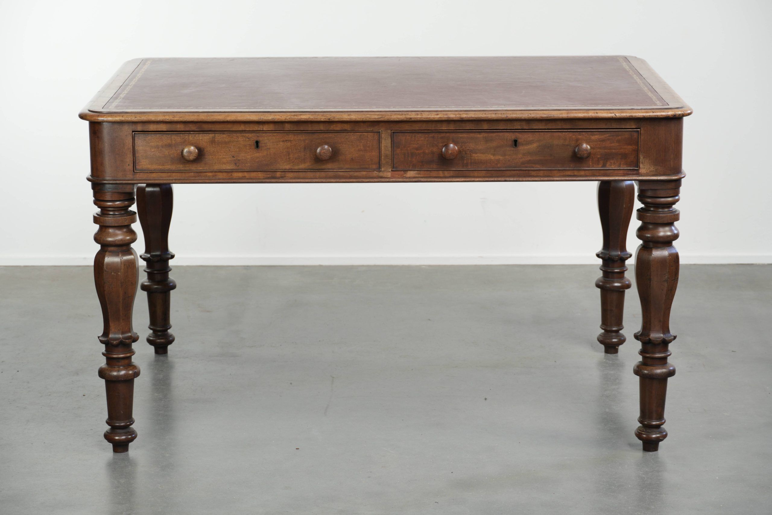 Antique English writing desk from the 19th century with a red leather top