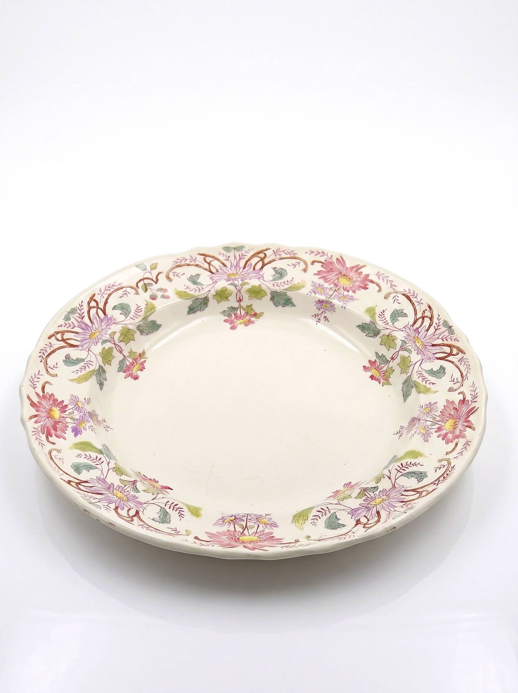 Antique Longchamp service shallow dish with polychrome daisies, ironstone, 19th century.