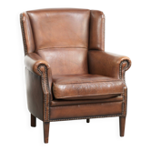 Fauteuil à oreilles en peau de mouton brun foncé subtil avec un look intemporel.