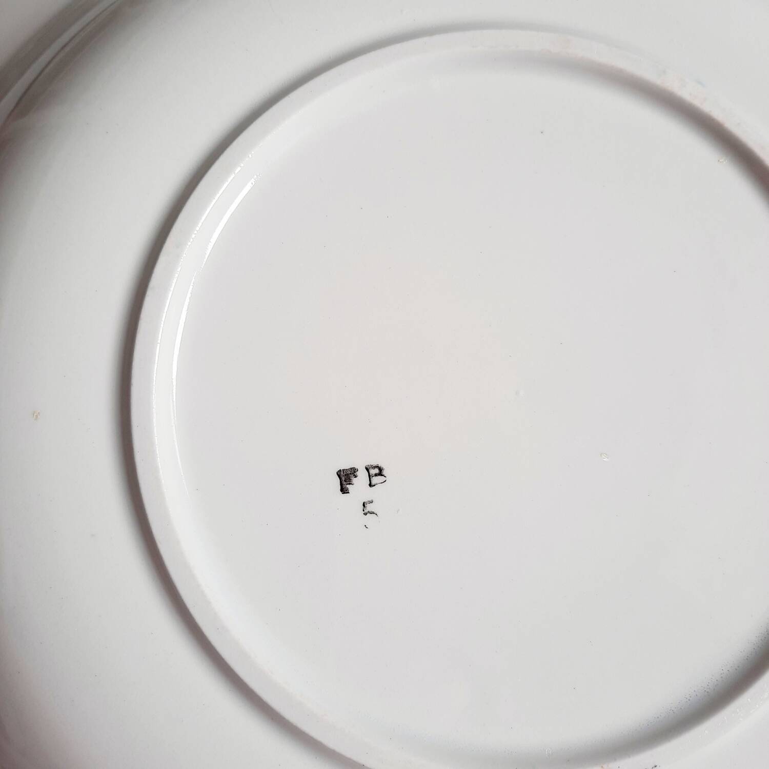 Old mismatched earthenware dinner plates accompanied by a deep dish