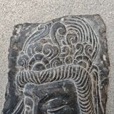 Antique portrait of Buddha hand-carved in stone, 19th century.