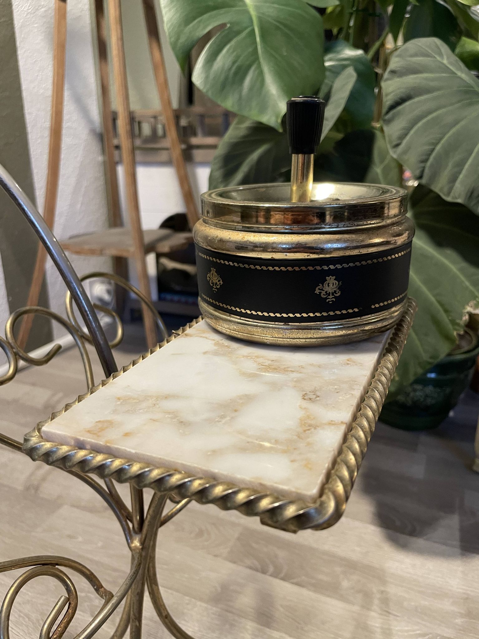 Gold wrought iron ashtray on legs with magazine rack and marbled shelf