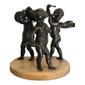 Three musician angels, bronze sculptures on a marble base.