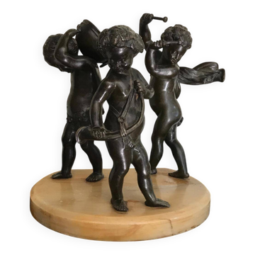 Three musician angels, bronze sculptures on a marble base.