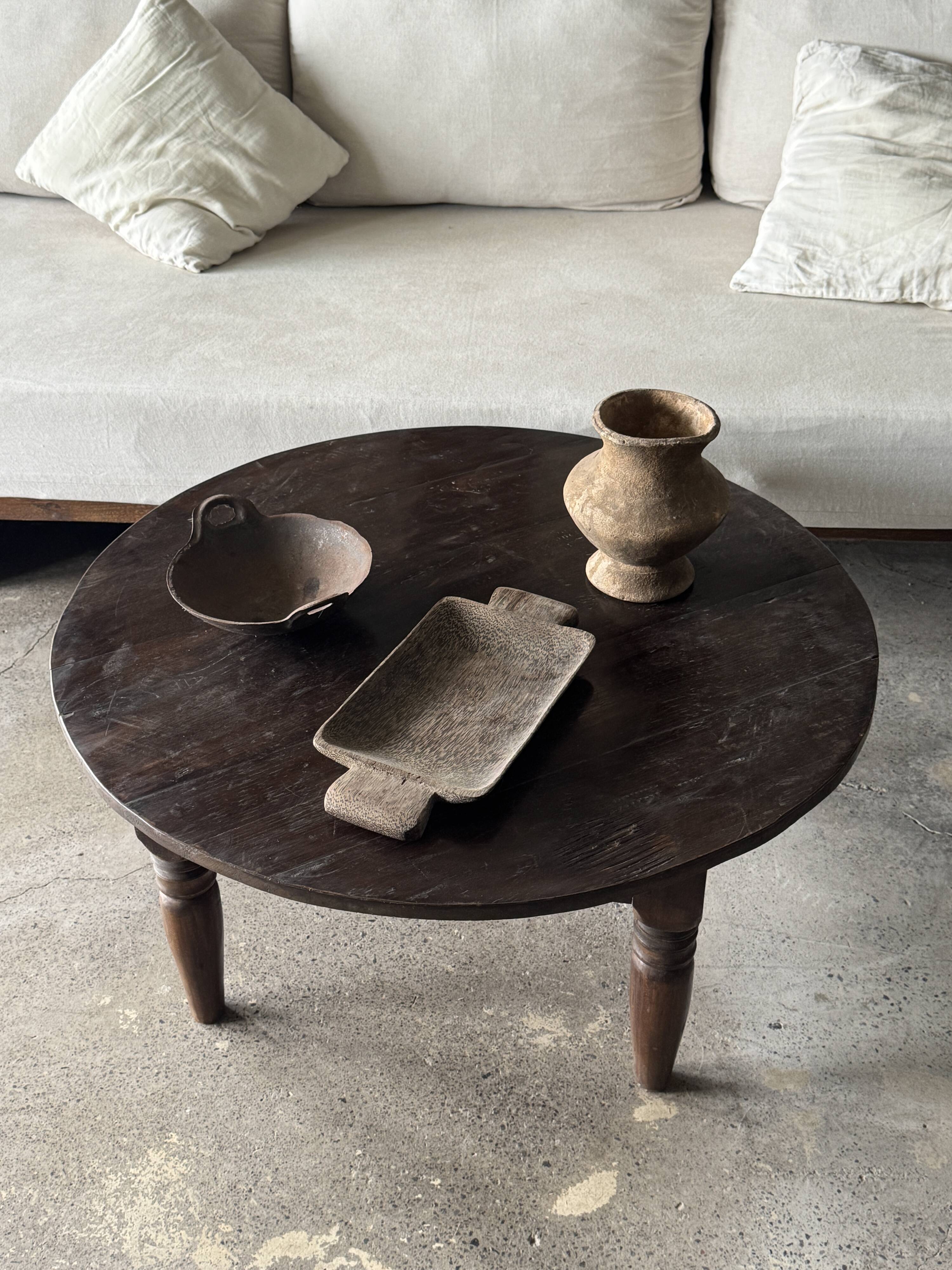 Coffee table, round antique Indonesian teak table with straight legs.