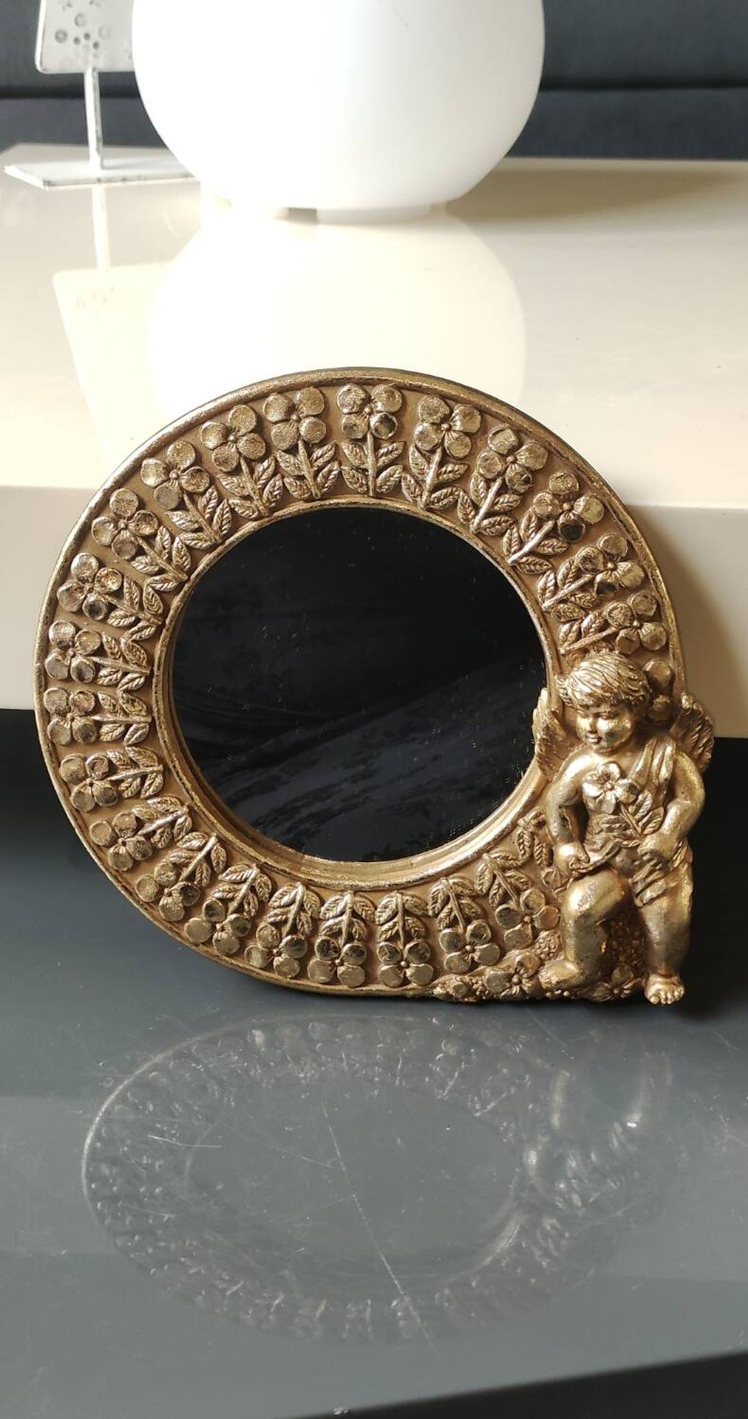 Shabby Chic round mirror. Putti/Cherub decor. Floral motifs. Dimensions: 20 x 20 cm.