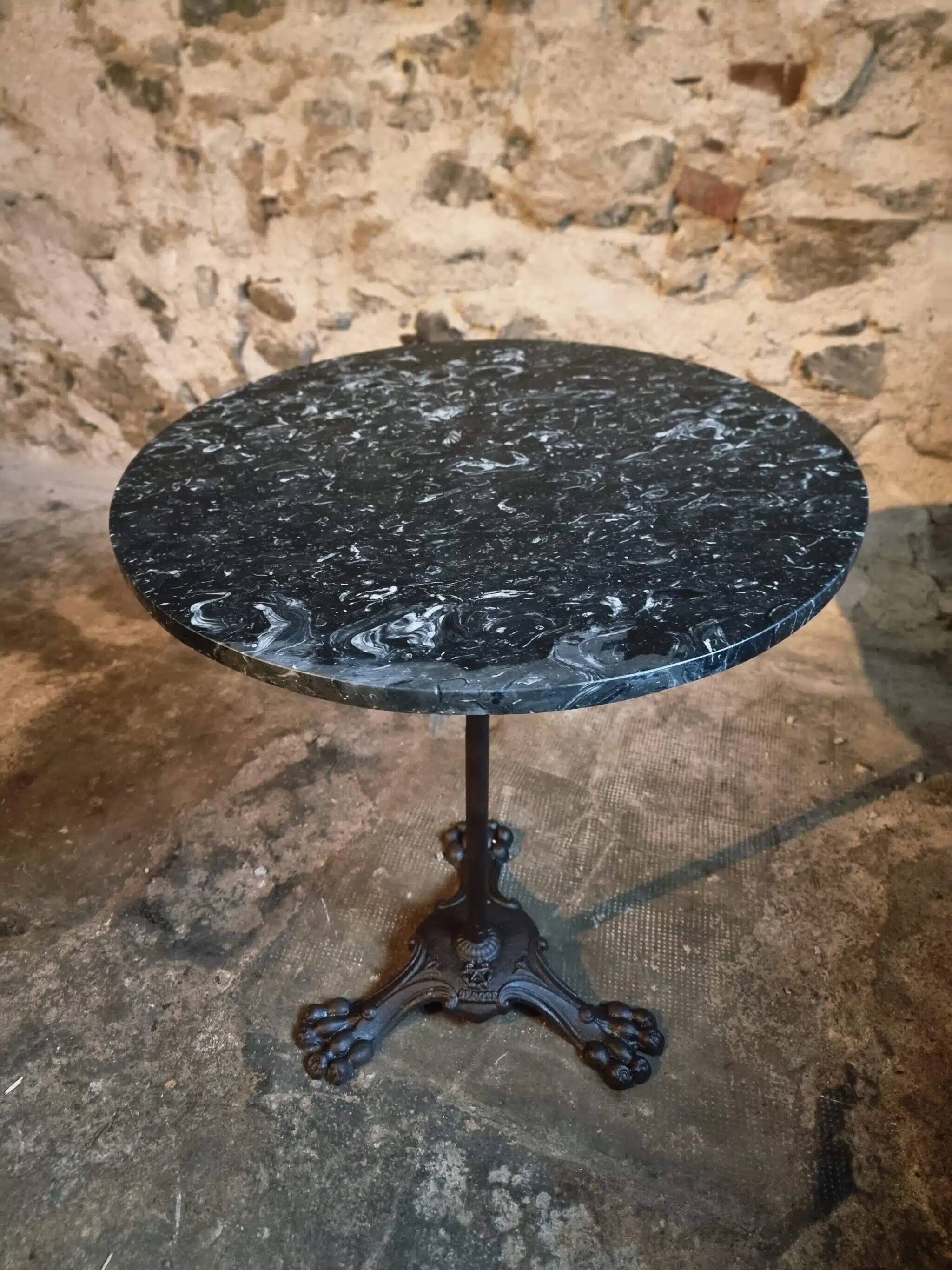 Old French bistro table with a marble top and a cast iron base.