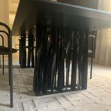 Table de salle à manger noire, en bois, rectangle avec chaises rembourrées.