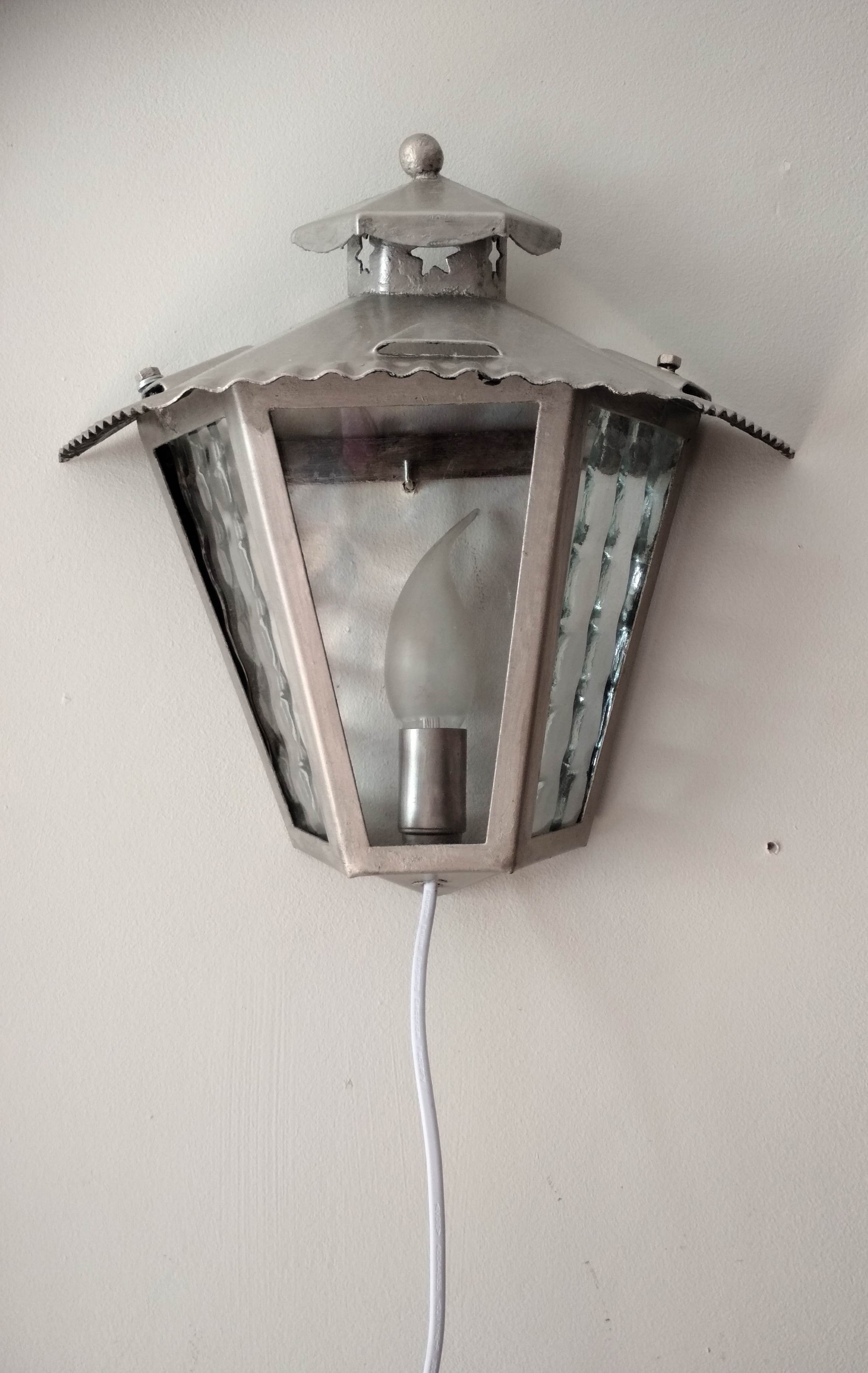 Half grey metal wall sconce and 3 windows