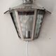 Half grey metal wall sconce and 3 windows
