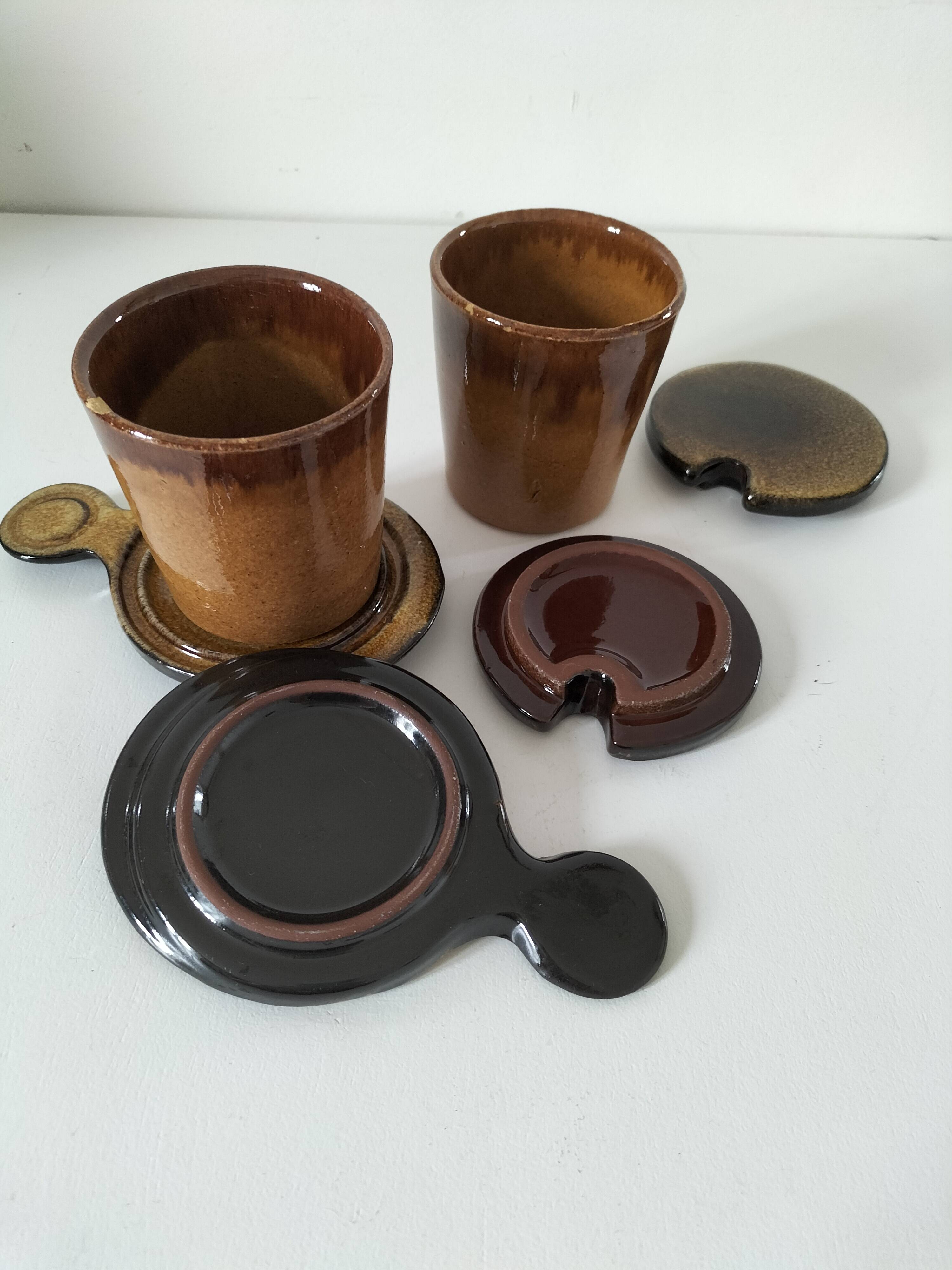 Pair of glazed stoneware cups with saucers and lids