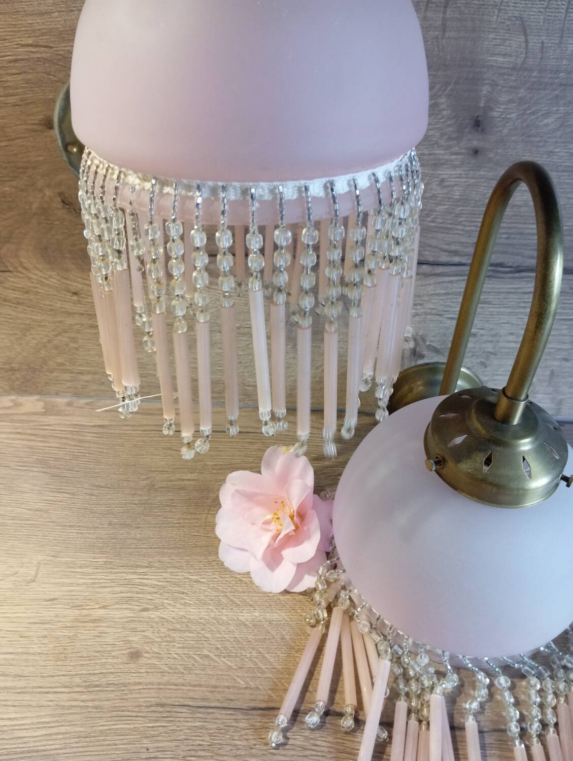 Brass swan neck wall lamp with pink glass globe and Charleston tassels