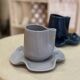 Set of ceramic artisan mugs with blue-grey pop water lily design.