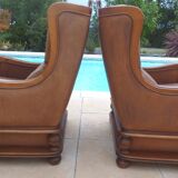 Pair of aged leather armchairs with seat and firm backrest with cherry wood frame