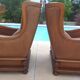 Pair of aged leather armchairs with seat and firm backrest with cherry wood frame
