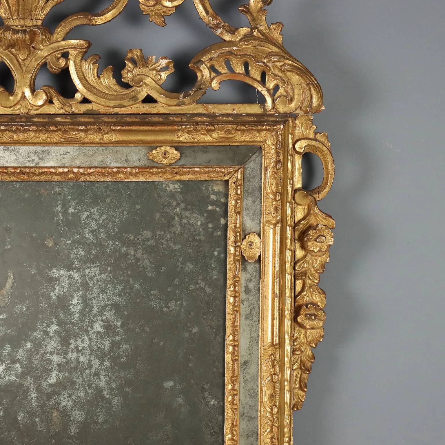 Antique gilded wooden mirror with rococo patterns, Italy, 18th century.