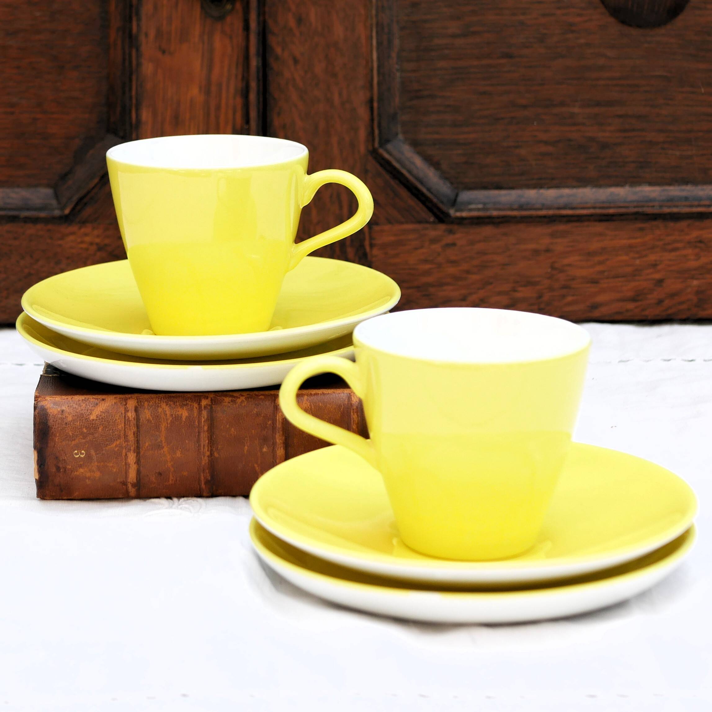 A pair of vintage bright yellow Poole Pottery - Two cups, saucers and ace