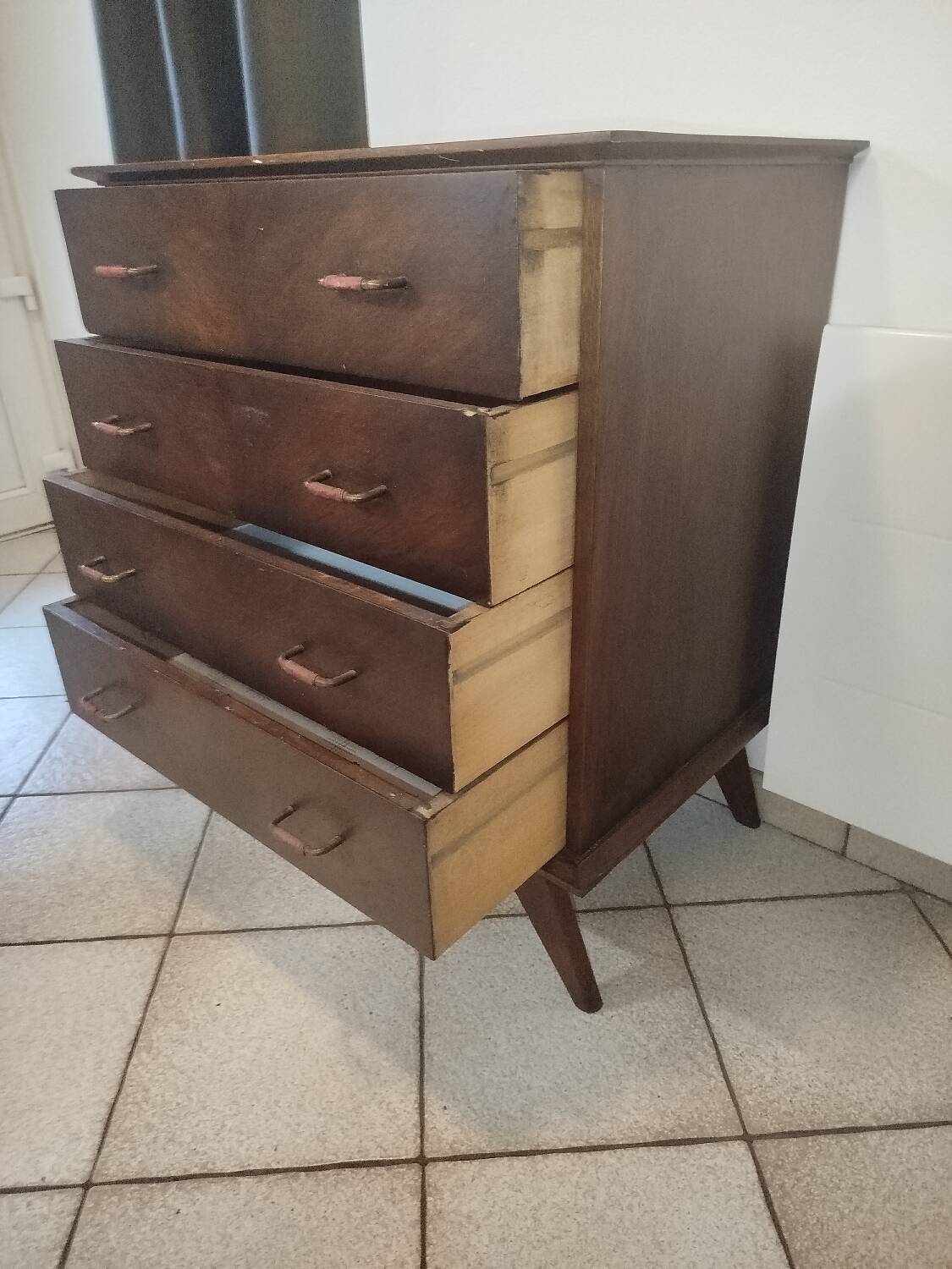 Vintage chest of drawers from the 1950s with wooden legs and a design feature.