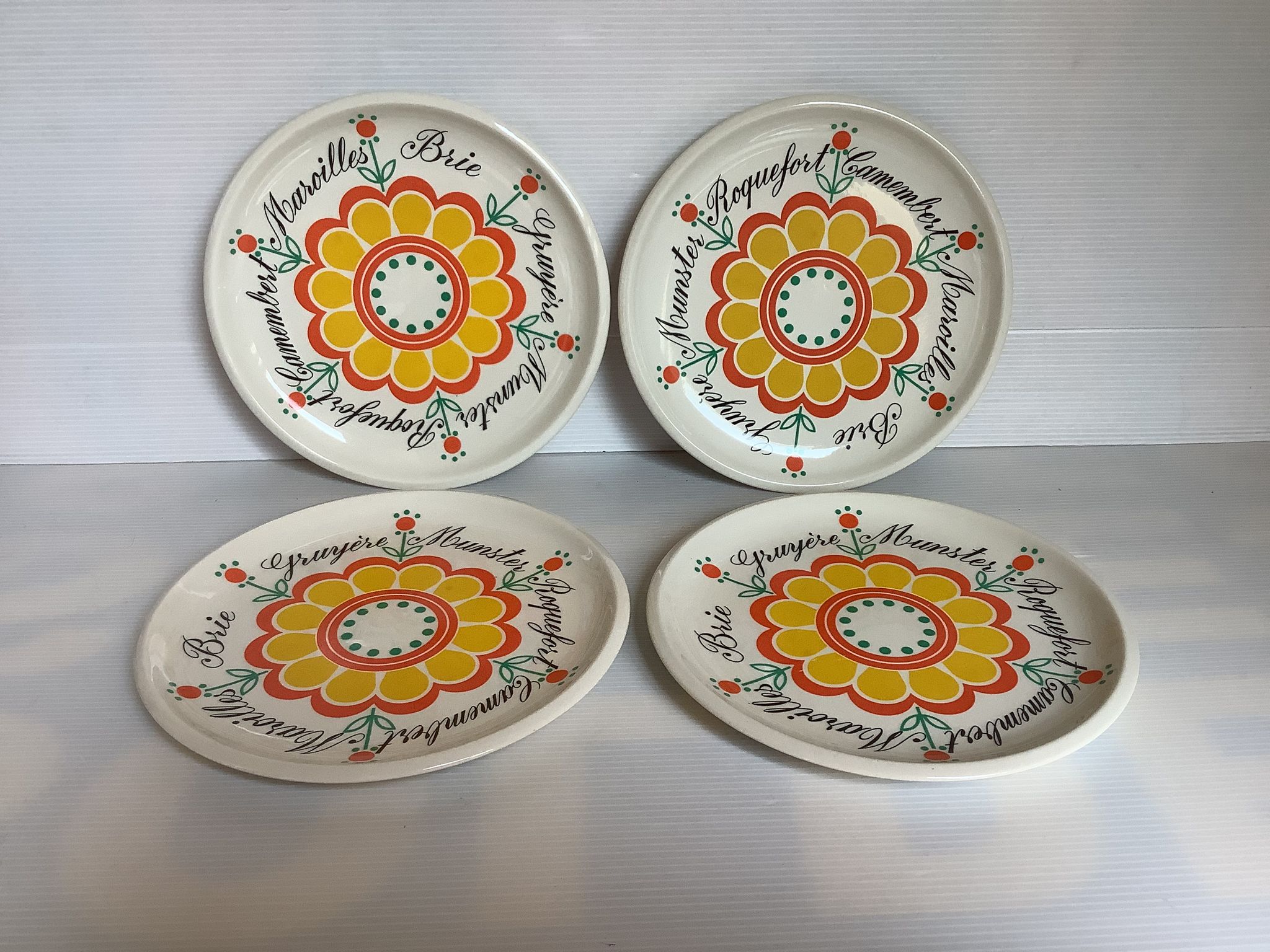 Four vintage floral cheese plates.