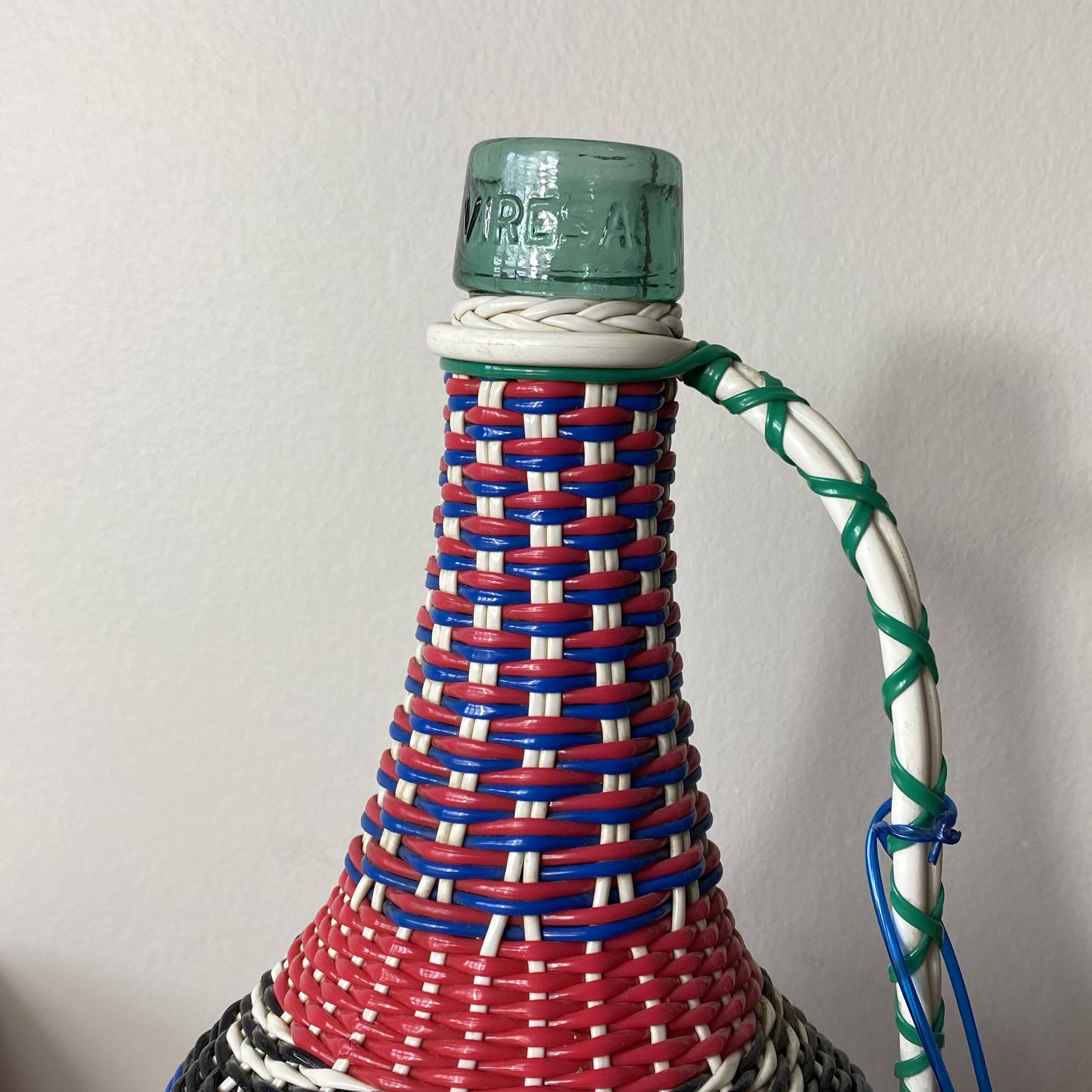 Old glass bottle and vintage scoubidou plastic weaving