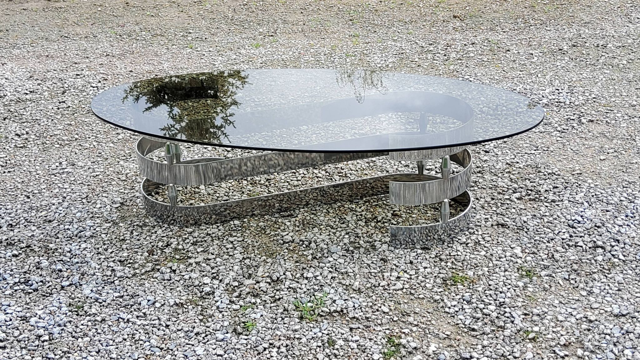 Oval coffee table of the 70s chromed metal base in s smoked glass top
