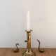Old brass candlestick with push button.