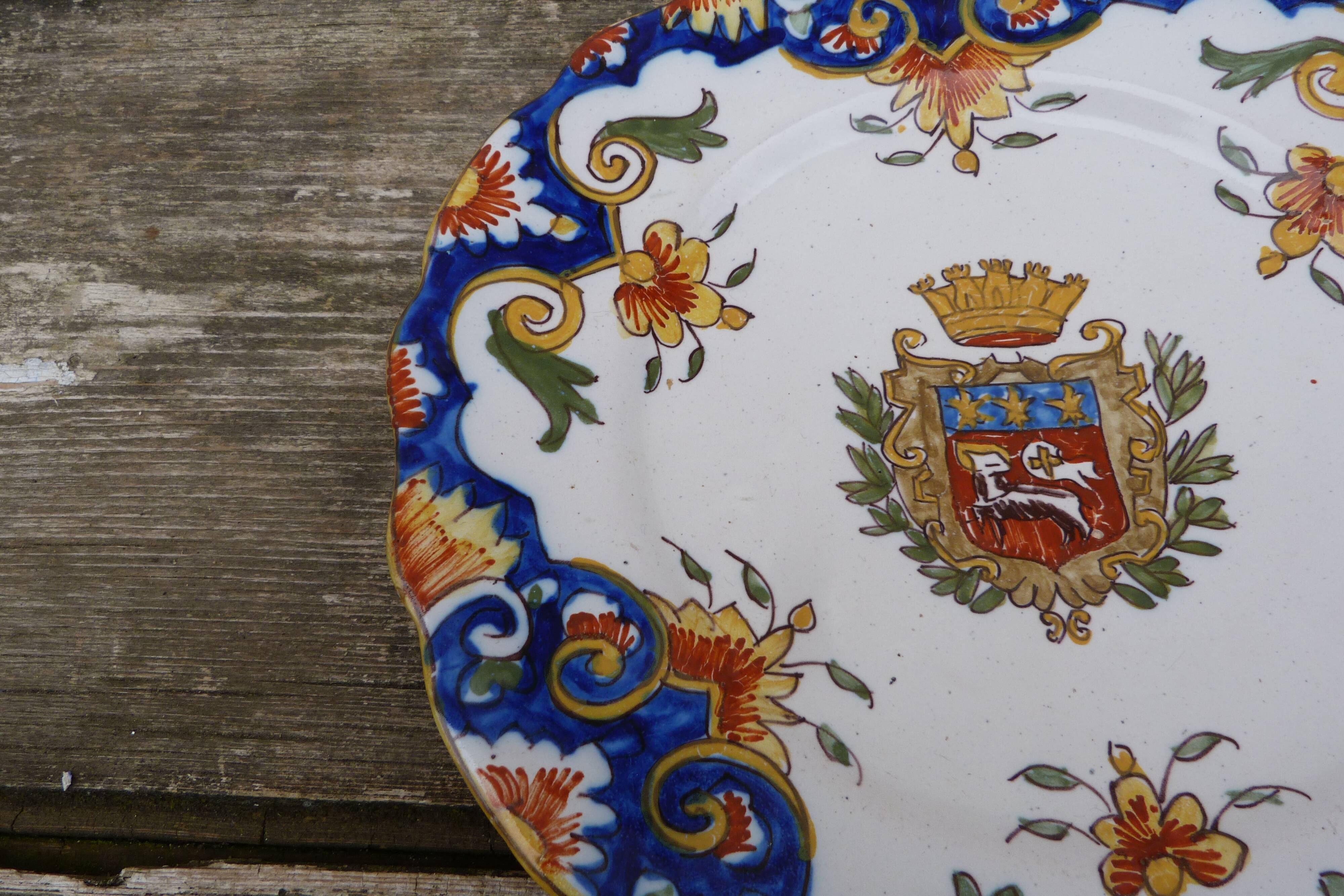 18th century plate in Rouen's faience with coat of arms and floral motifs