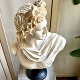 Beige bust of Apollo on black pedestal