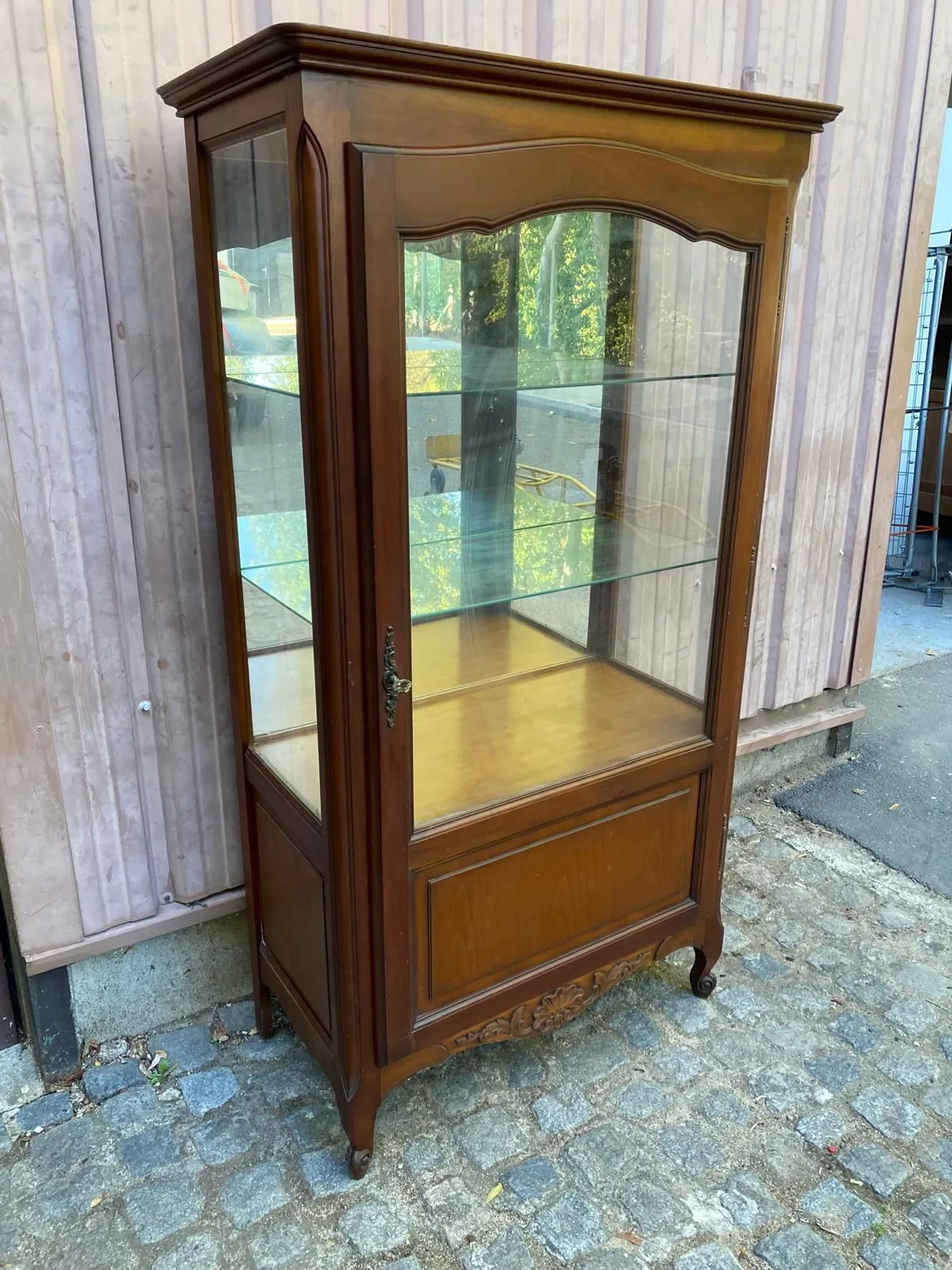 Louis XV style display cabinet in cherry wood with a mirrored back and glass shelves.