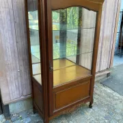 Louis XV style display cabinet in cherry wood with a mirrored back and glass shelves.