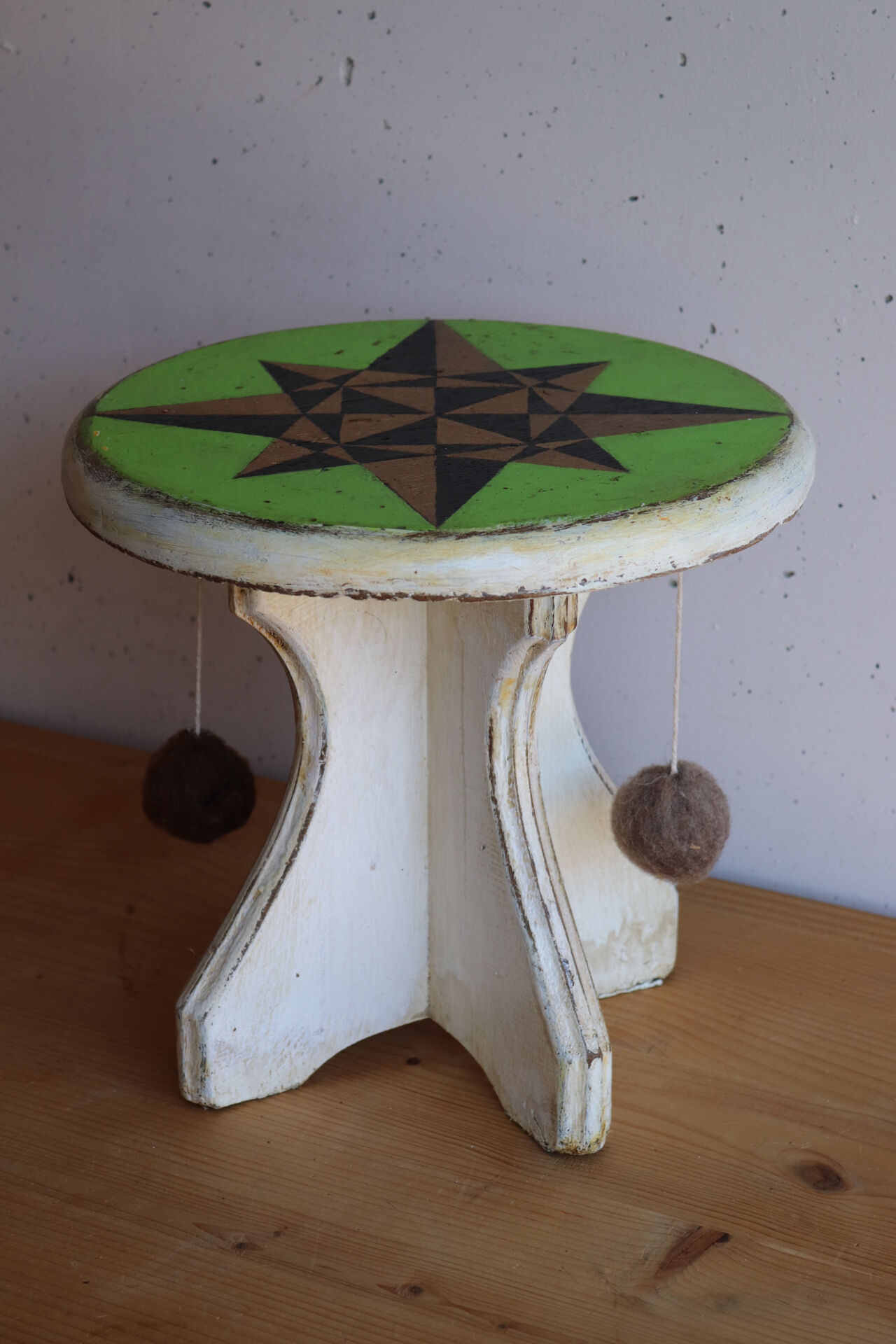 Small wooden stool painted with a star design.