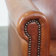 Cognac-colored cow leather club chair finished with decorative nails in English style