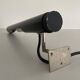 Minimalist black metal wall light with a cylindrical design, 1960s, Germany.