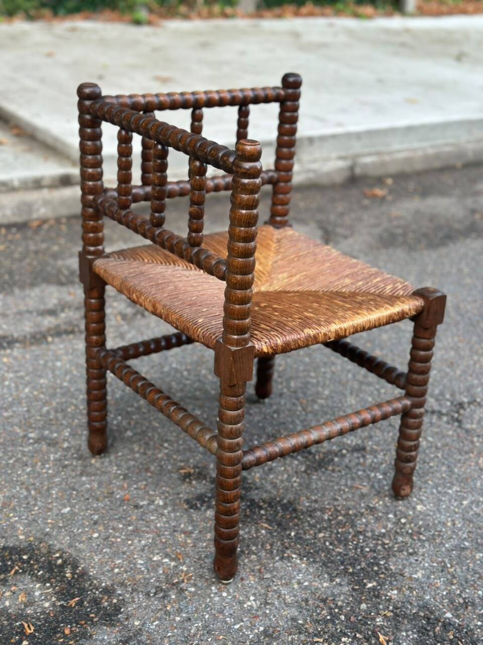 Brutalist corner chair in turned wood with straw bobbins, 1960.