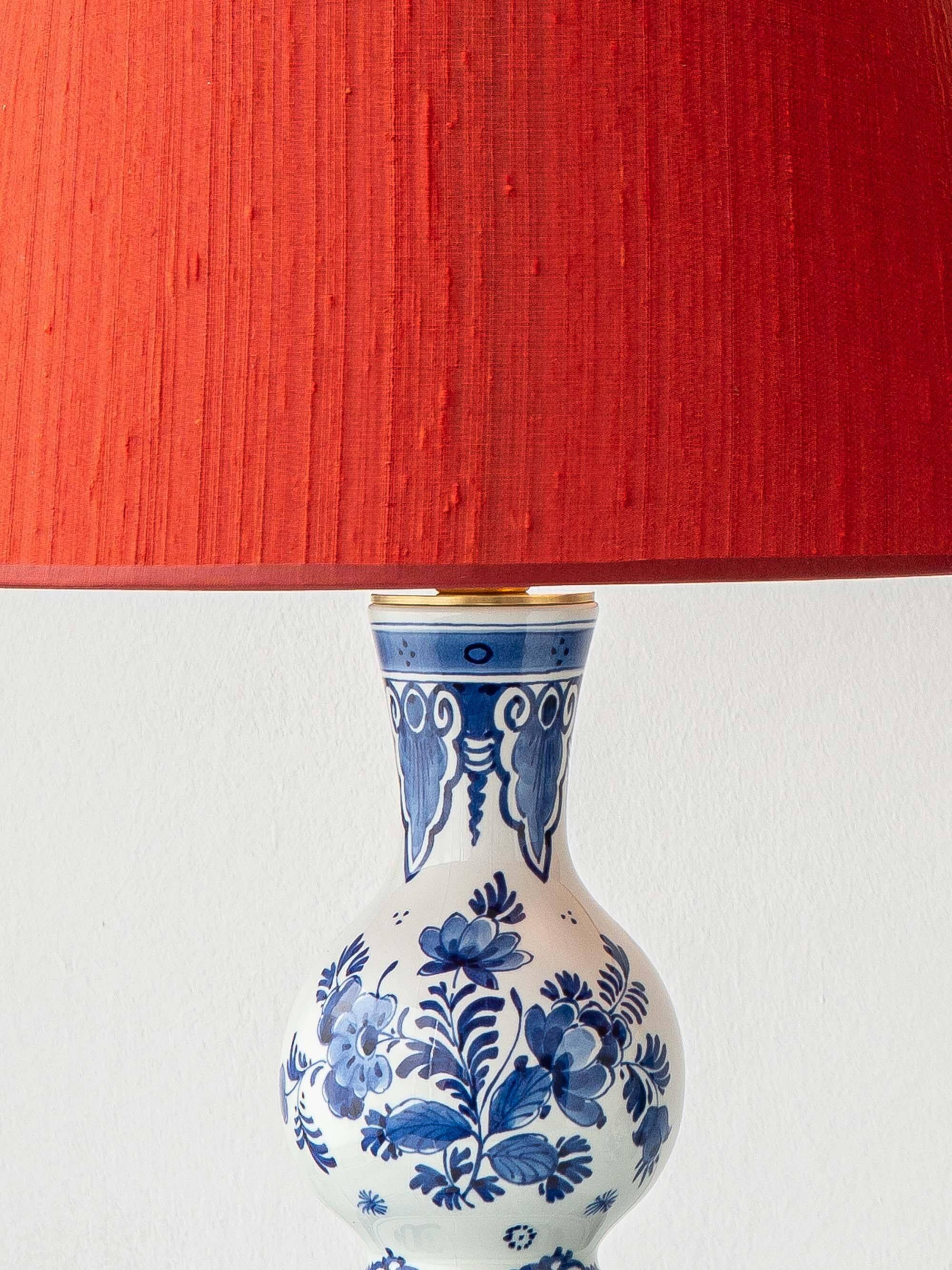 Pair of Royal Delft blue and white ceramic table lamps with new vermilion silk shades.
