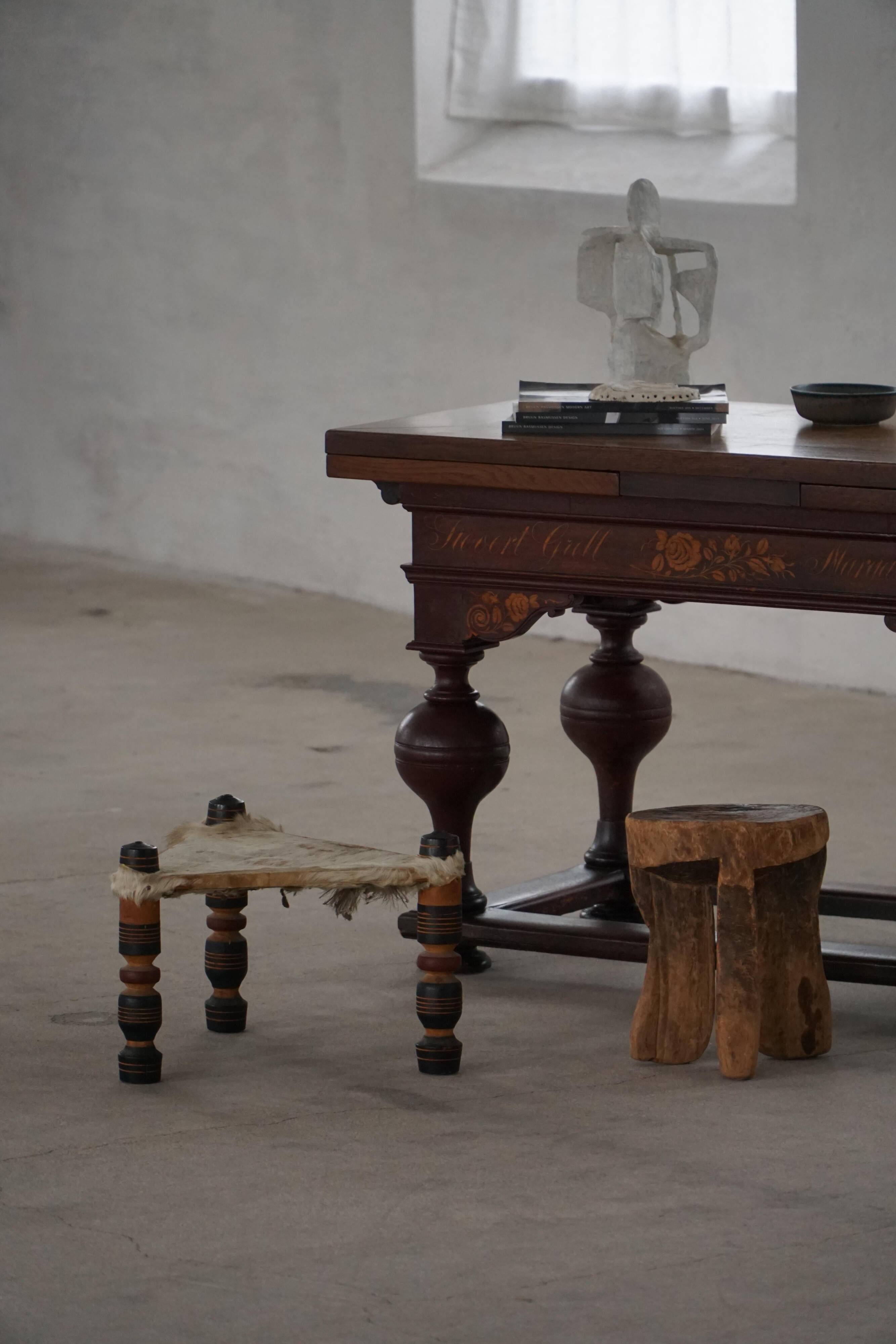 Vintage African artisanal stool, triangular shape with 3 legs, cowhide, 20th century.