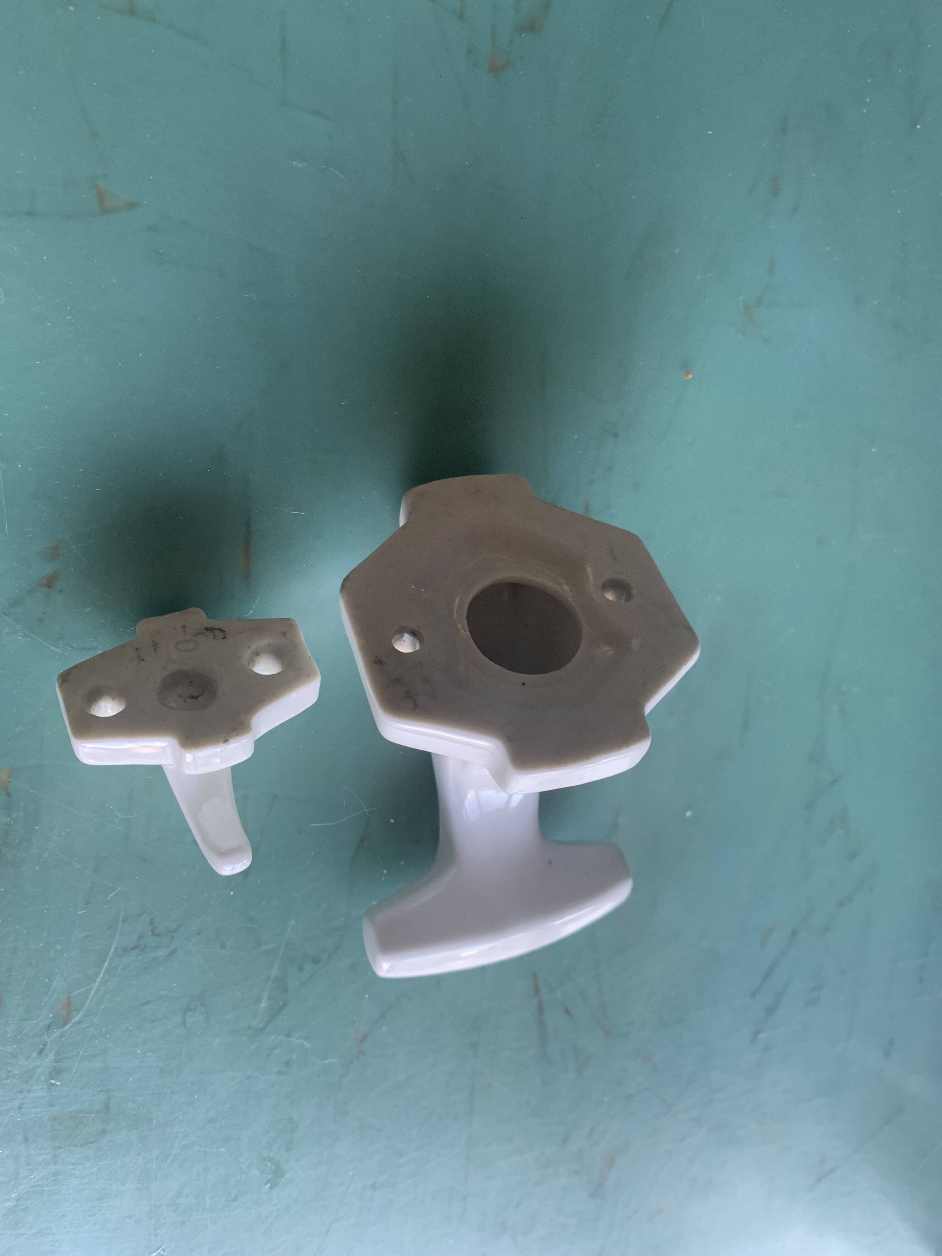 Two white porcelain coat hooks, one small and one larger, old