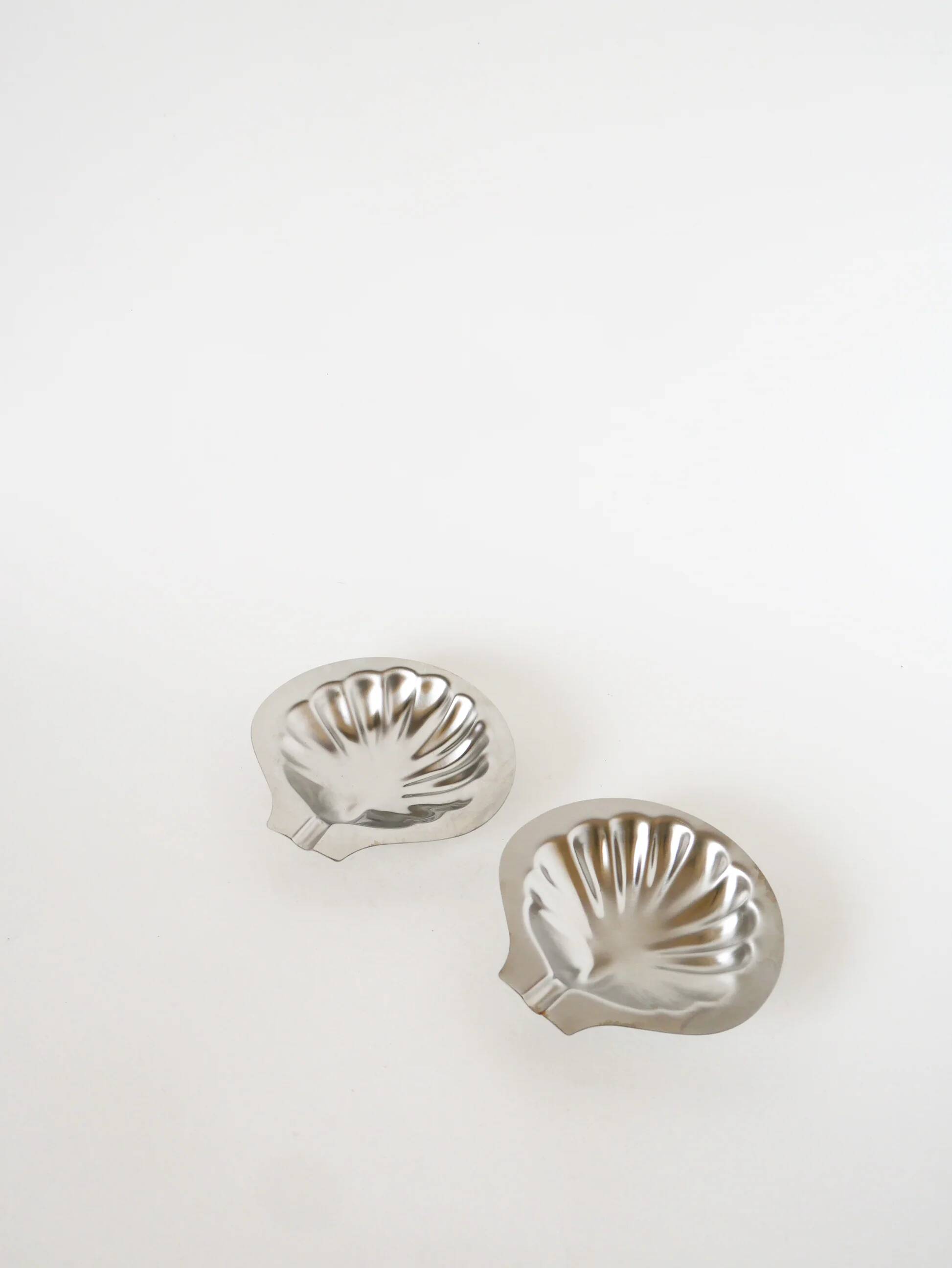 Pair of shell-shaped stainless steel catchalls, design, 1970
