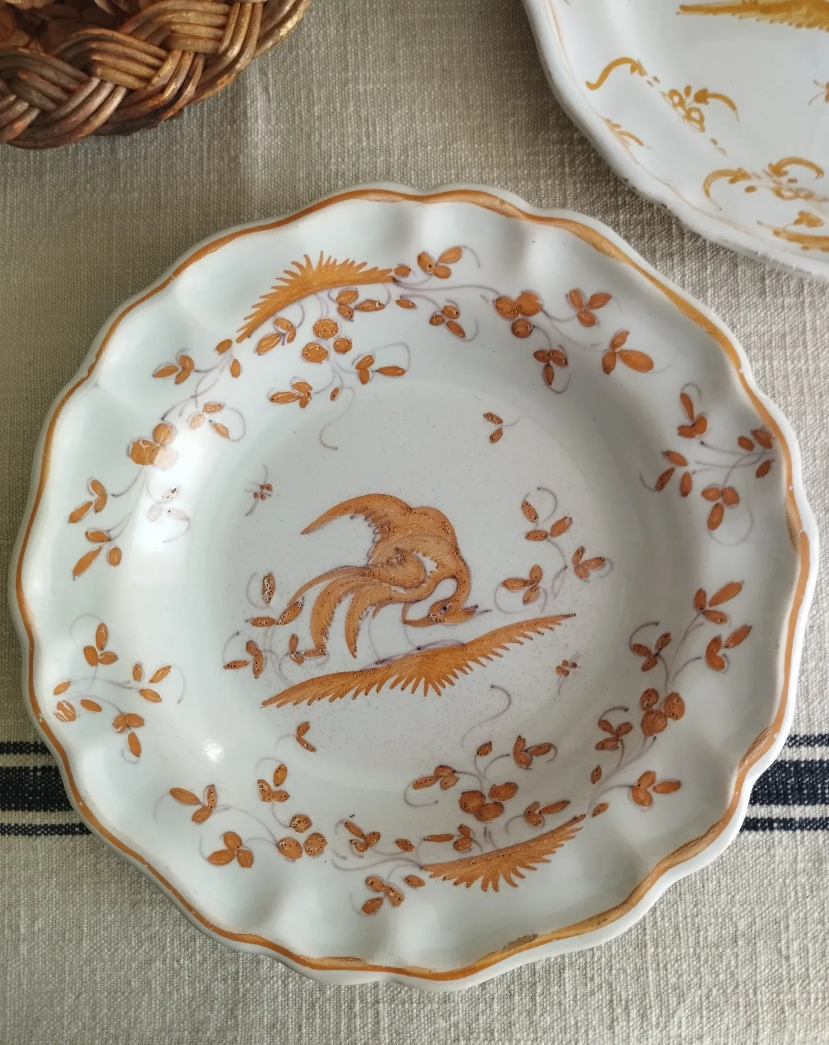Pair of antique plates with a bird of paradise design in the style of Moustiers.