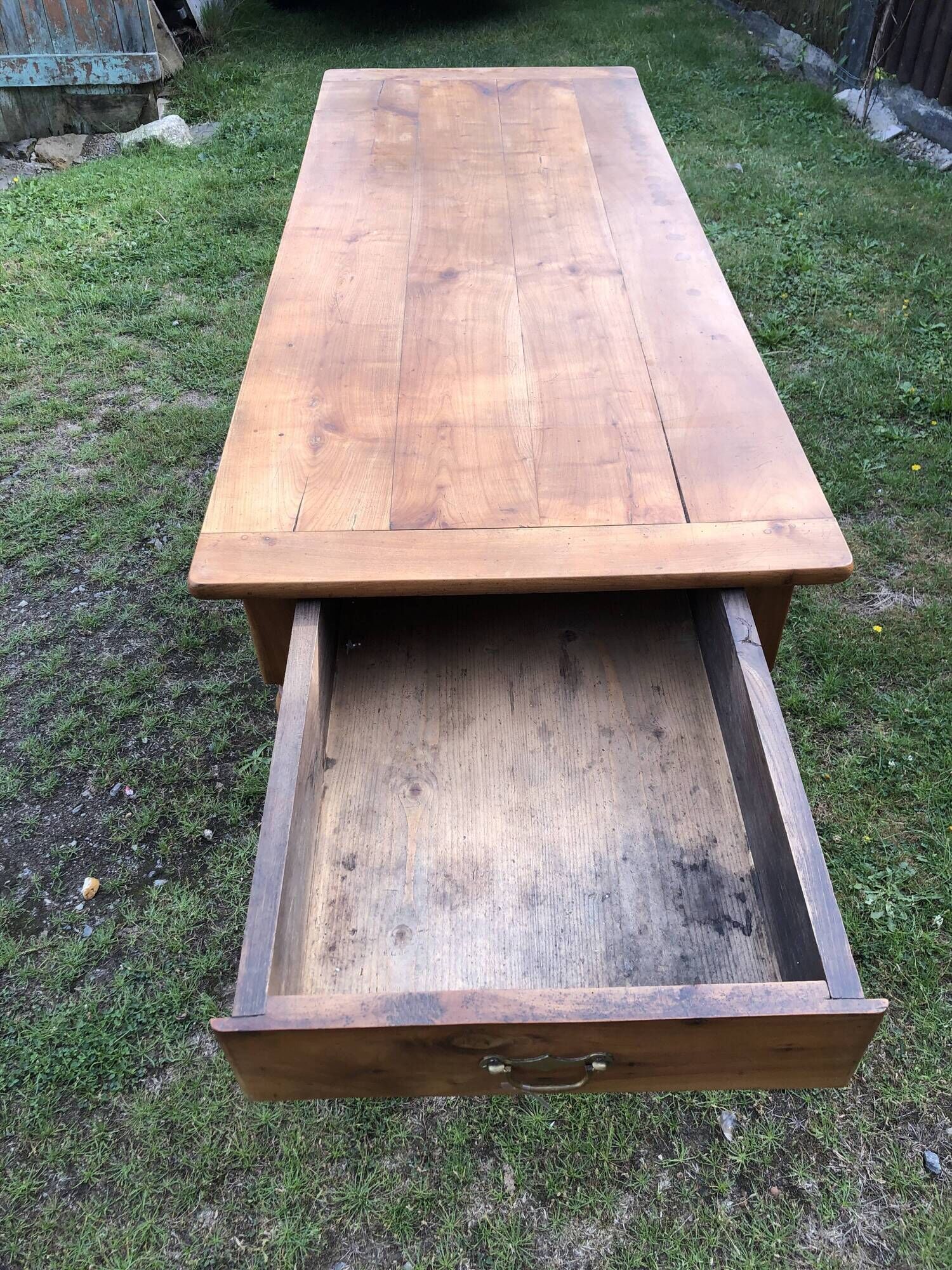 Antique farmhouse table in solid cherry wood with 2 drawers and 1 pull-out at the end with turned legs.