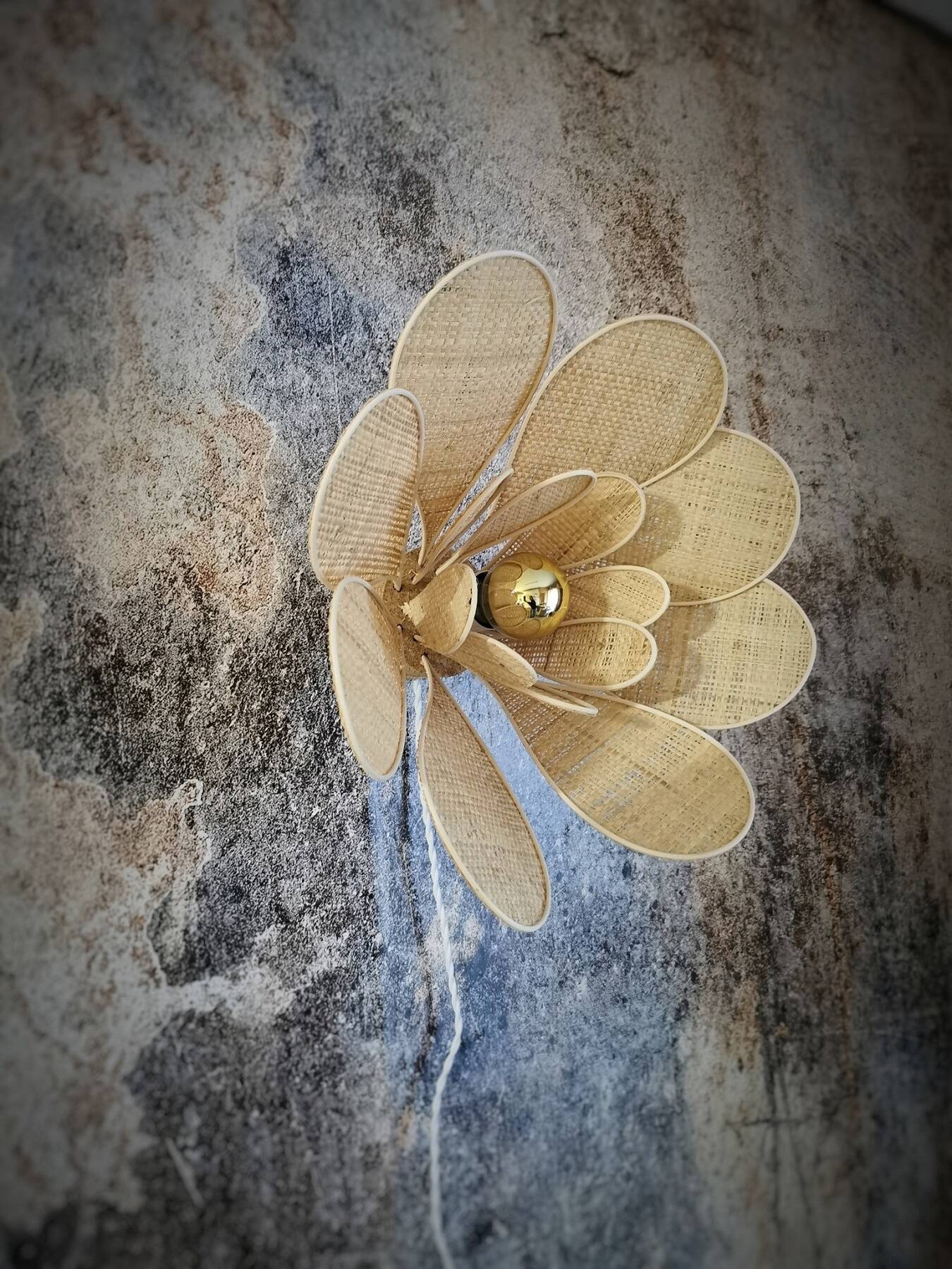 Flower wall light made of rattan and raffia petals