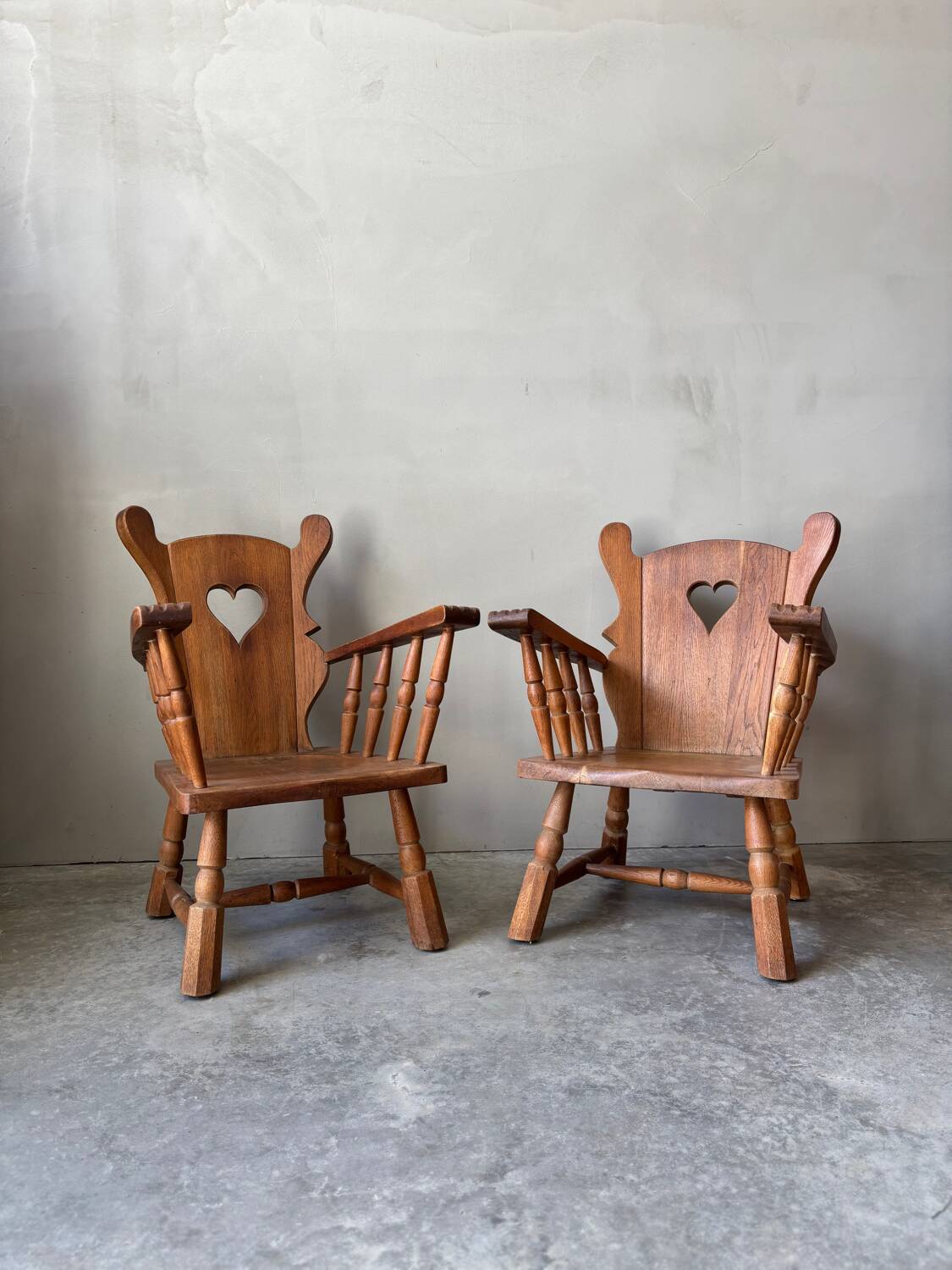 Pair of rustic oak armchairs – carved heart backrests