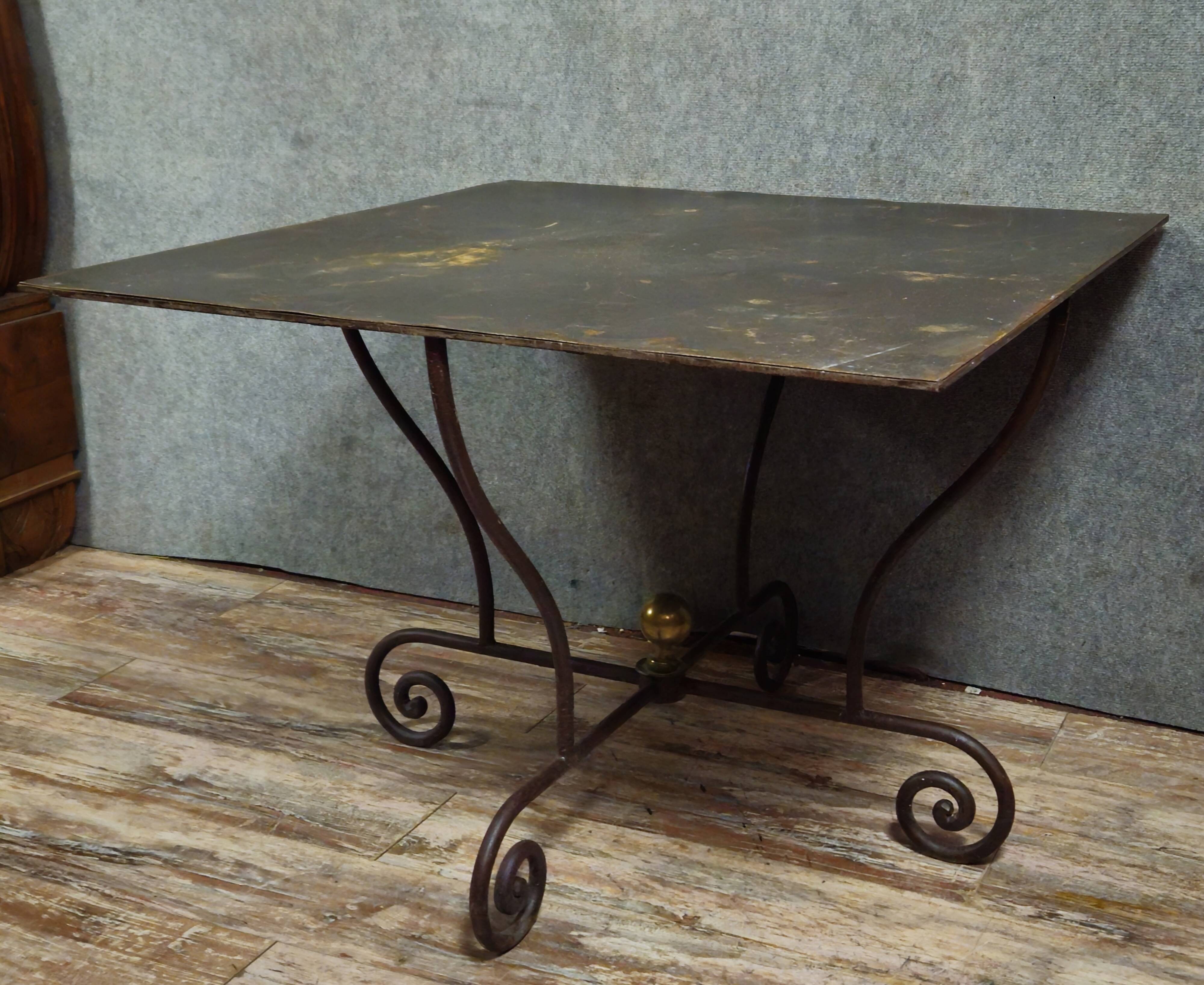 Table en fer forgé à piétement sculptural, ornée de volutes