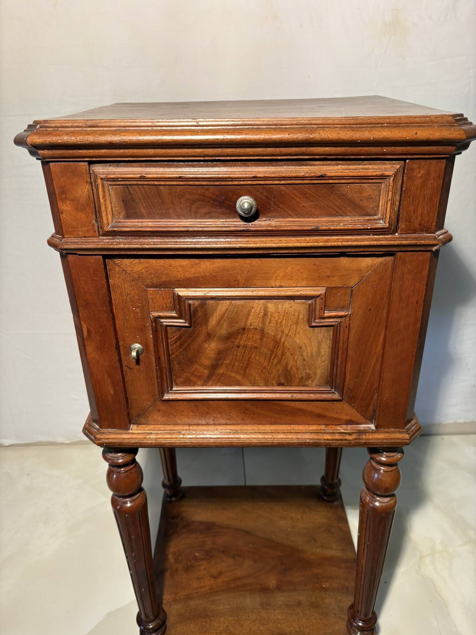 Antique wooden bedside table with turned legs.