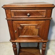 Antique wooden bedside table with turned legs.