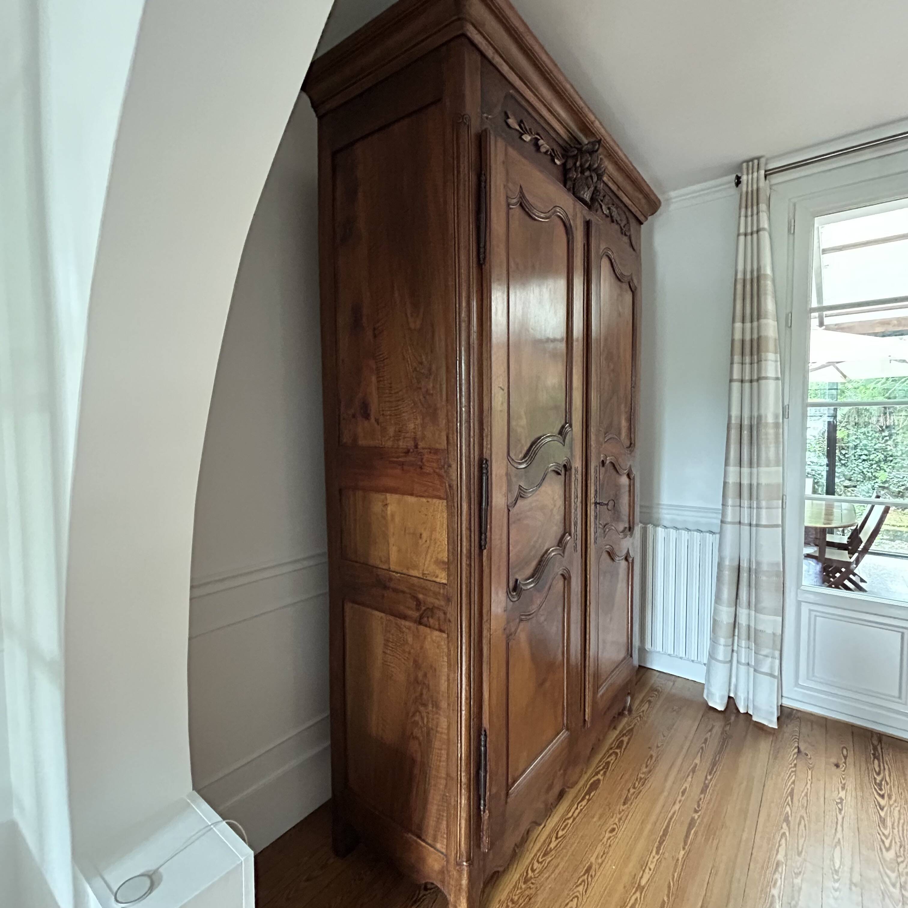 Antique walnut armoire with two doors.