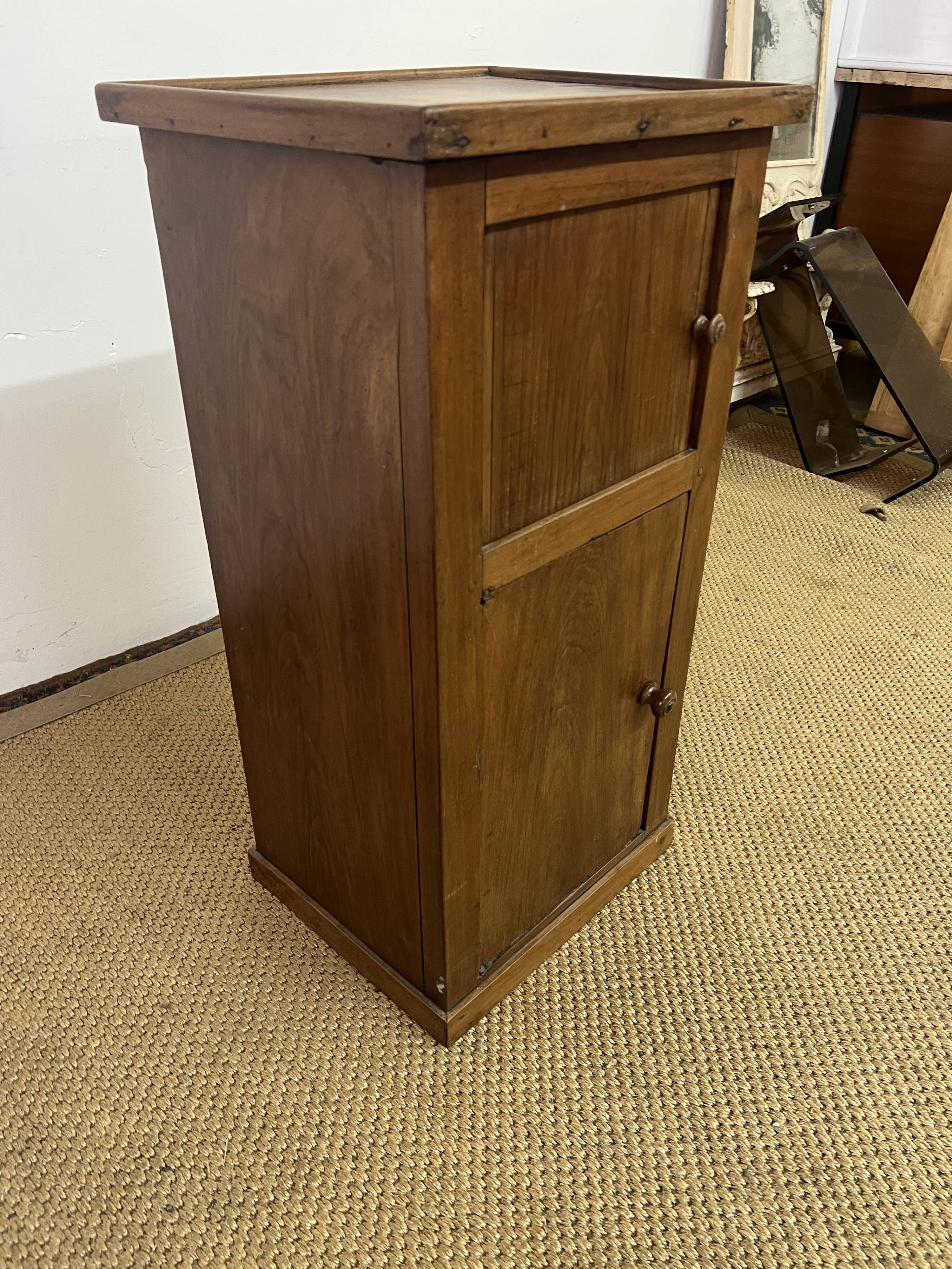 Old small storage unit with sliding and hinged doors.