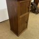 Old small storage unit with sliding and hinged doors.